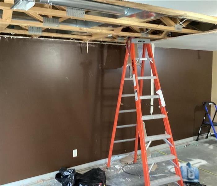 room with ceiling gone and an orange ladder