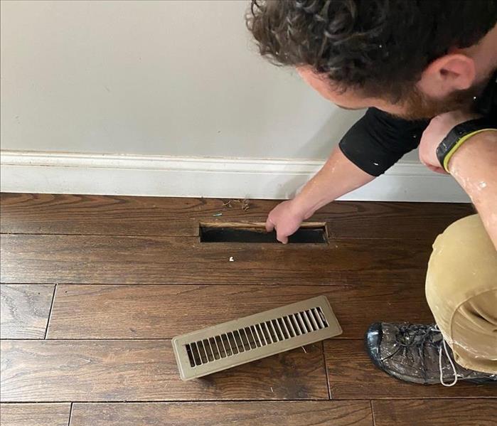 person touching the vent on the floor